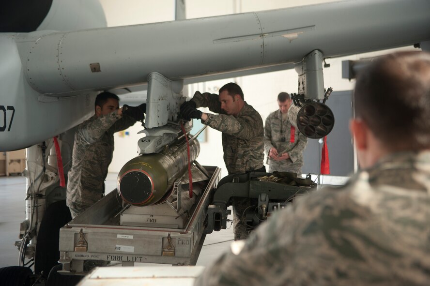 Members of the 74th Aircraft Maintenance Unit work together to use an MHU-83 Jammer to lift a cluster bomb into place on an A-10C Thunderbolt II during an A-10 Weapons Load Crew of the Quarter Competition at Moody Air Force Base, Ga., Jan. 11, 2013. The team raced against the clock to load various munitions onto the aircraft and their time was added to their overall score. (U.S. Air Force photo by Airman Paul Francis/Released) 
