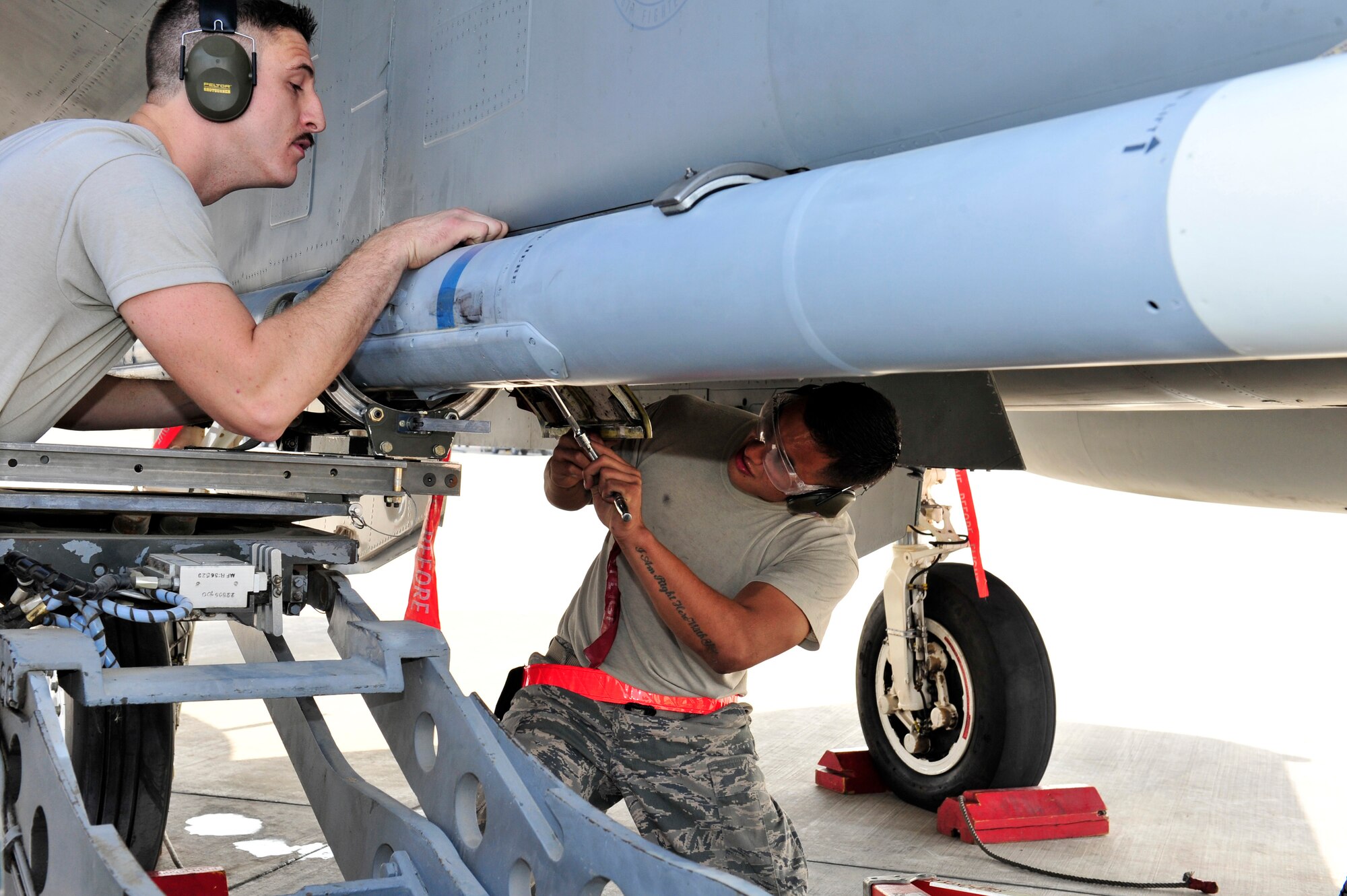 SOUTHWEST ASIA -- U.S. Air Force Senior Airmen Jason Early and Nicholas Balagat, 380th Expeditionary Aircraft Maintenance Squadron weapons load crew members, load a missile to an F-15 Eagle Jan. 13, 2013. Weapons load crews from multiple airframes competed for the "Best Loading Crew" title during the 380th Air Expeditionary Maintenance Group quarterly Weapons Loading Competition. (U.S. Air Force photo/Tech. Sgt. Christina M. Styer) (RELEASED) 