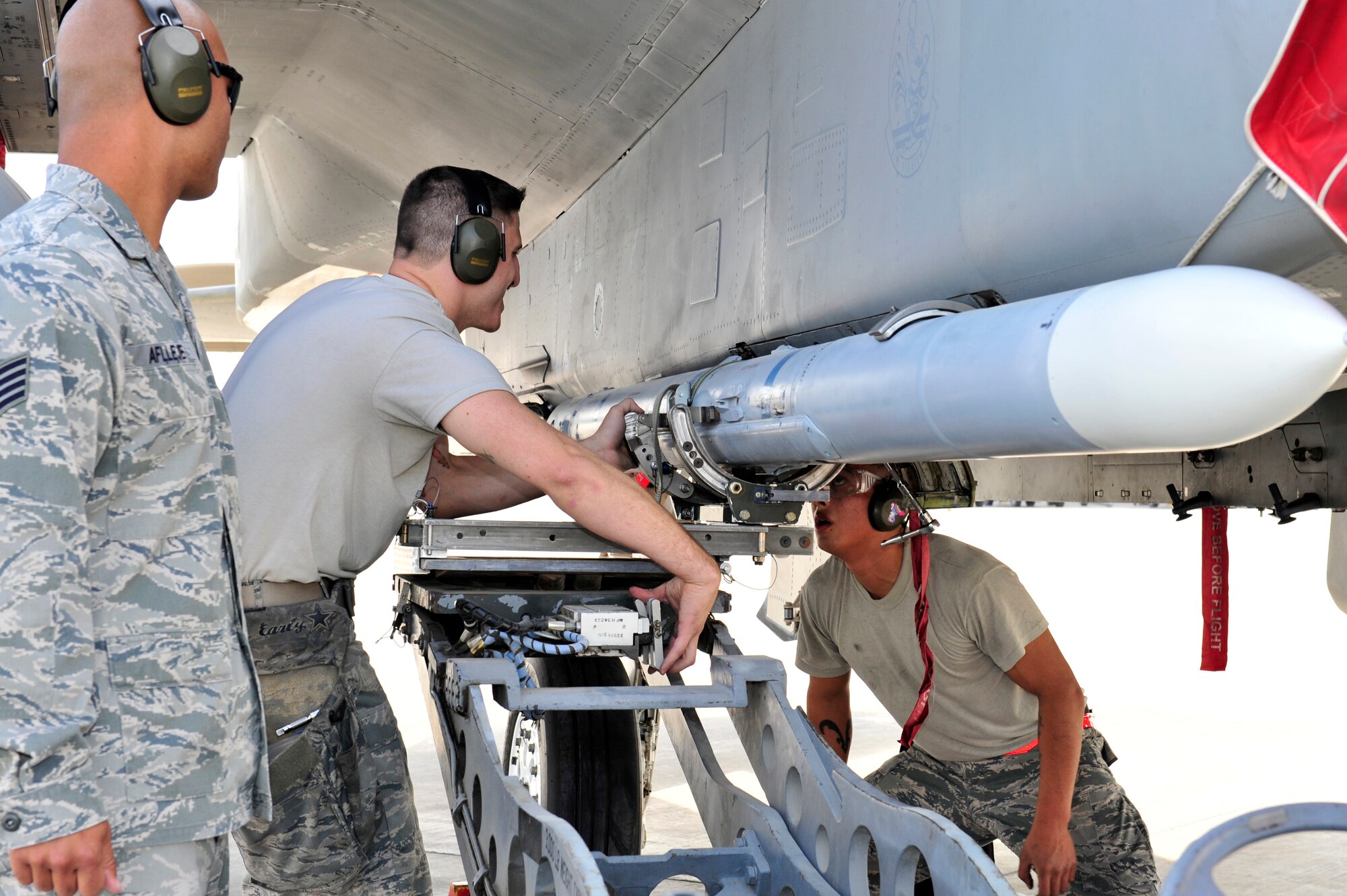 SOUTHWEST ASIA -- U.S. Air Force Staff Sgt. Christopher Aflleje, 380th Expeditionary Aircraft Maintenance Squadron weapons standardization technician, inspects the installation of a missile on an F-15 Eagle during the quarterly Weapons Loading Competition Jan. 13, 2013. Weapons Standardization inspectors checked the accuracy and timeliness of weapons load crews from several airframes during the competition. (U.S. Air Force photo/Tech. Sgt. Christina M. Styer) (RELEASED)