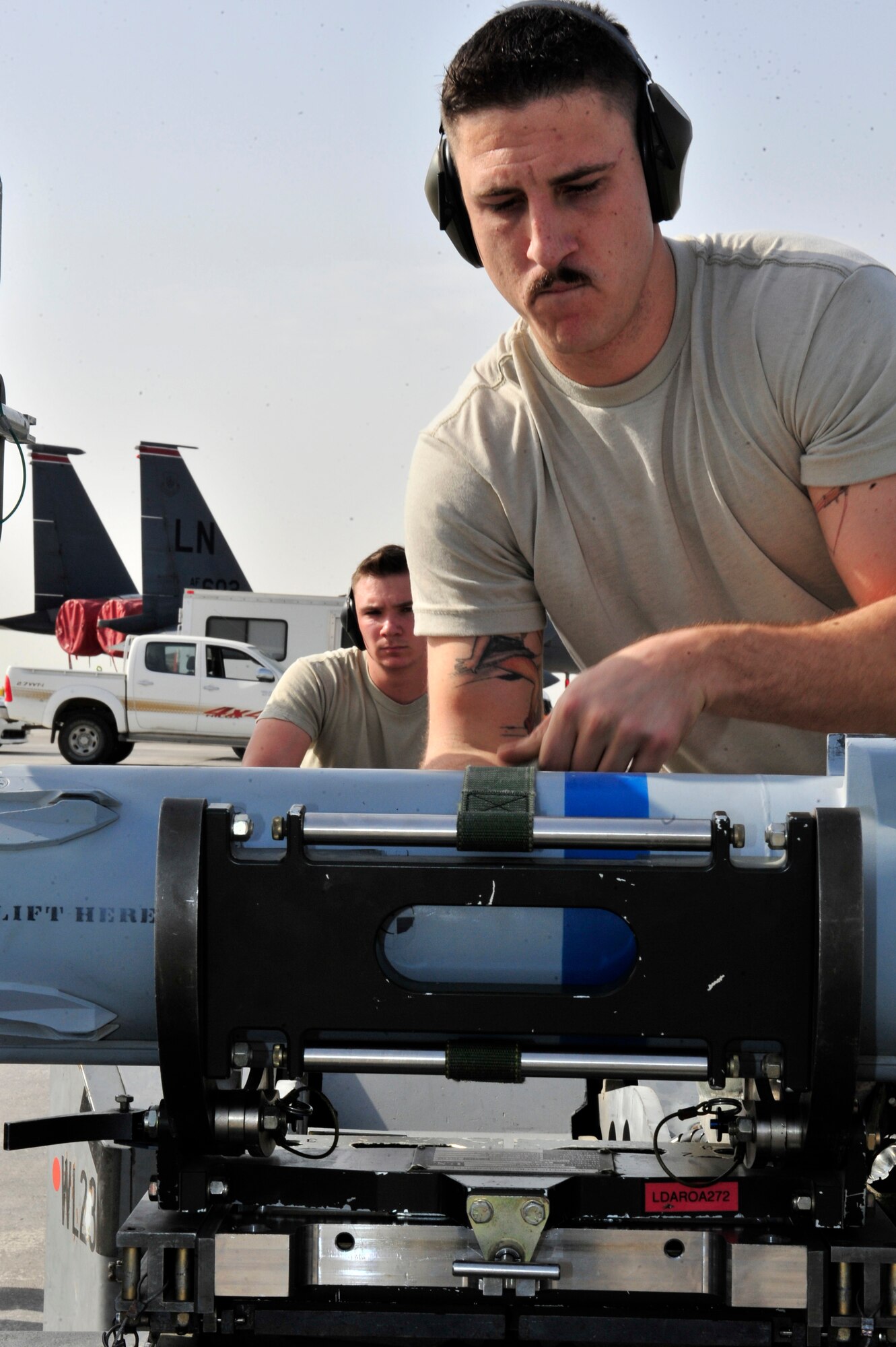 SOUTHWEST ASIA -- U.S. Air Force Senior Airman Jason Early and Airman 1st Class Sean McNelly, 380th Expeditionary Aircraft Maintenance Squadron weapons load crew members, prepare a missile to be loaded during the Weapons Loading Competition Jan. 13, 2013. The load crew, deployed from Kadena Air Base, Japan, faced-off against crews from other airframes to demonstrate their teamwork skills and proficiency in the deployed environment. (U.S. Air Force photo/Tech. Sgt. Christina M. Styer) (RELEASED) 