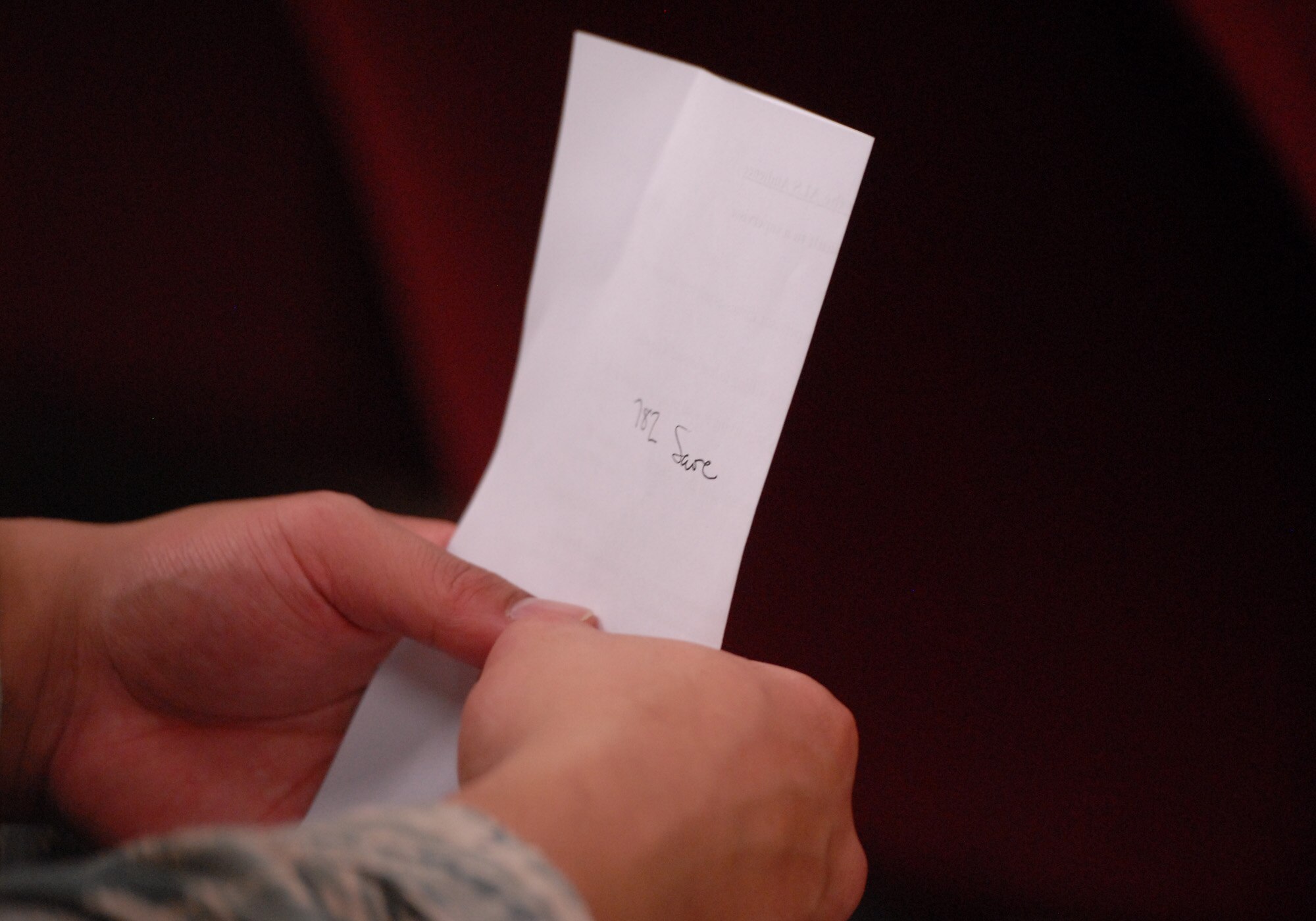 An audience member writes down a help line number for the sexual assault response coordinator Dec. 19, 2012, during a sexual assault theater group skit at Kunsan Air Base, Republic of Korea. The theater group was designed to help future supervisors  recognize signs of sexual assault or guide the victim to a helpful source. (U.S. Air Force photo by Staff Sgt. Tong Duong/Released)