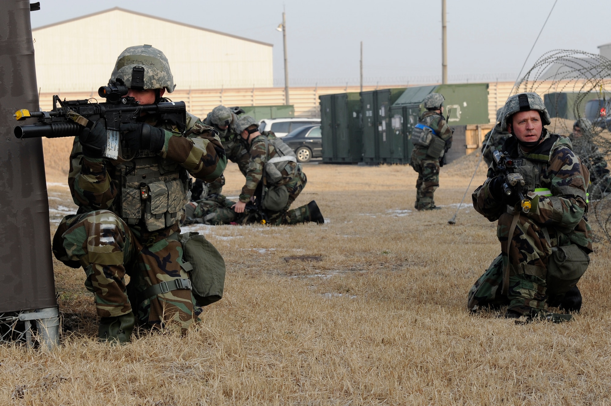Airman 1st Class Blake Boston, left, and Master Sgt. Daniel McClay, right, 8th Security Forces Squadron, protect Airmen treating wounded during exercise Beverly Midnight 13-1 at Kunsan Air Base, Republic of Korea, Jan 15, 2013. The 8th SFS quickly eliminated the enemy threat while keeping their teammates stabilized. (U.S. Air Force photo by Senior Airman Marcus Morris/released)
