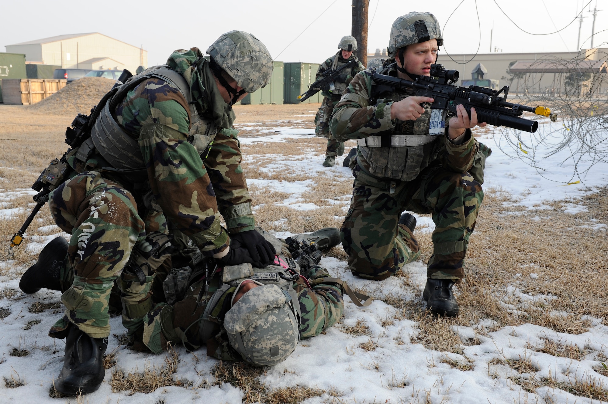 Airman 1st Class Dalton Gilreath, left, 8th Security Forces Squadron treats a simulated sucking chest wound on an Airman while calling for assistance from Airman 1st Class Blake Boston, 8th SFS as Airman 1st Class Dylan Coenen, right, 8th SFS, covers the area during Exercise Beverly Midnight 13-1 at Kunsan Air Base, Republic of Korea, Jan 15, 2013. The Airmen quickly set up a perimeter while using combat Self-Aid and Buddy Care to stabilize the simulated wounded. (U.S. Air Force photo by Senior Airman Marcus Morris/released)