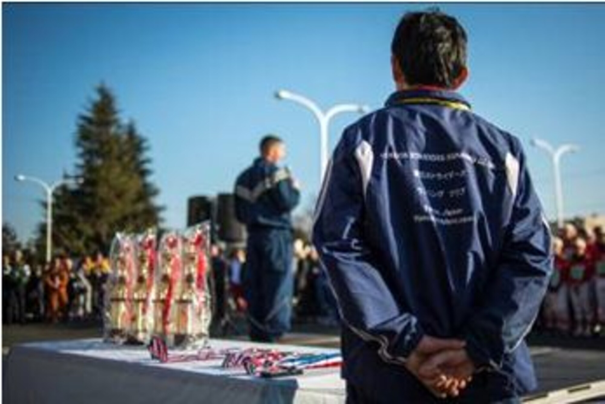 YOKOTA AIR BASE, Japan -- A Yokota Striders volunteer watches as Col. Ed Brown, 374th Mission Support Group commander, addresses participants at the opening ceremony of the annual Frostbite Run Jan. 13, 2013, at Yokota Air Base, Japan. Team Yokota welcomed more than 10,000 Japanese runners from the local area during the annual event. (U.S. Air Force photo Capt. Raymond Geoffroy)