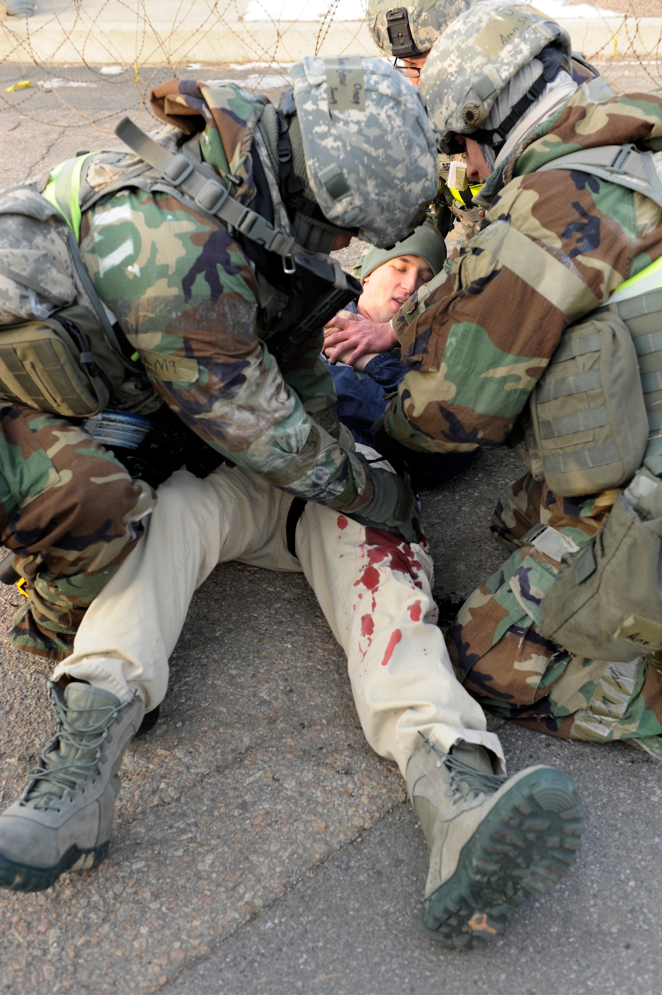 Members of 8th Security Forces Squadron treat a teammate who was simulated shot in an opposing forces attack during Exercise Beverly Midnight 13-1 at Kunsan Air Base, Republic of Korea, Jan 15, 2013. The Airmen quickly stopped the bleeding by using combat Self-Aid and Buddy Care. (U.S. Air Force photo by Senior Airman Marcus Morris/released)