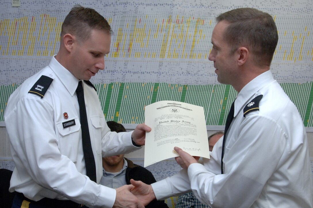 Lt. Col. James A. DeLapp (Right), U.S. Army Corps of Engineers Nashville District commander, presents a certificate of promotion to newly promoted Capt. Allen Stansbury, project officer at Wolf Creek Dam Foundation Remediation Project, during a promotion ceremony Jan. 11, 2013 in Jamestown, Ky. (USACE photo by Leon Roberts)