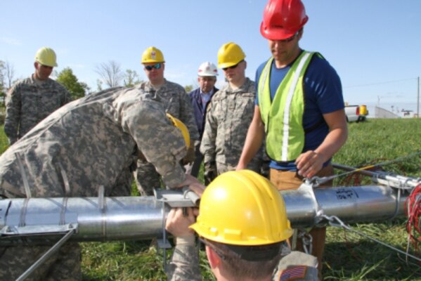 New Hampshire Army National Guard engineers erect a 34-meter meteorological tower on the Guard’s Regional Training Institute at Center Strafford, N.H. Nick Laskovski (red helmet), Wind Energy Project Analyst, EAPC Wind Energy, LLC., Norwich, Vt., and ERDC’s Dr. Charles Ryerson, principal investigator, Terrestrial and Cryospheric Sciences, (USACE helmet) provided guidance and technical expertise.