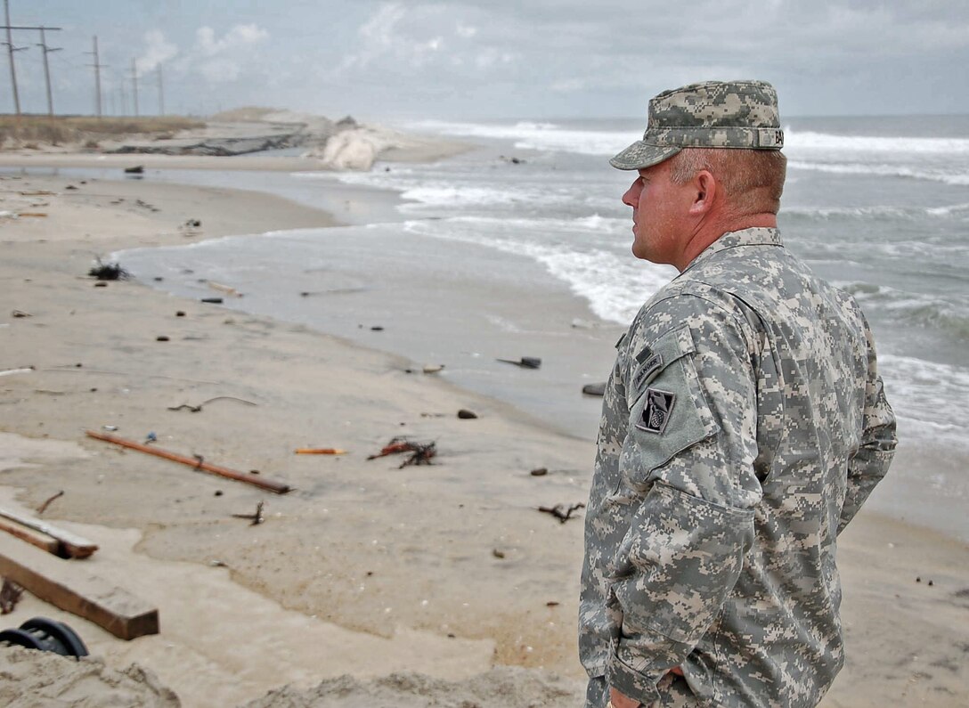 Wilmington District Commander Col. Steve Baker surveys damage to Highway 12 after Hurricane Irene hit coastal North Carolina in late August of 2011.  When the highway breached at Rodanthe the only access to the town and other parts of the Outer Banks was by ferry.  The dredge MERRITT helped ensure that ferries could get supplies and equipment to the hard hit areas by removing shoals from the federal channel.  (USACE photo by Hank Heusinkveld)