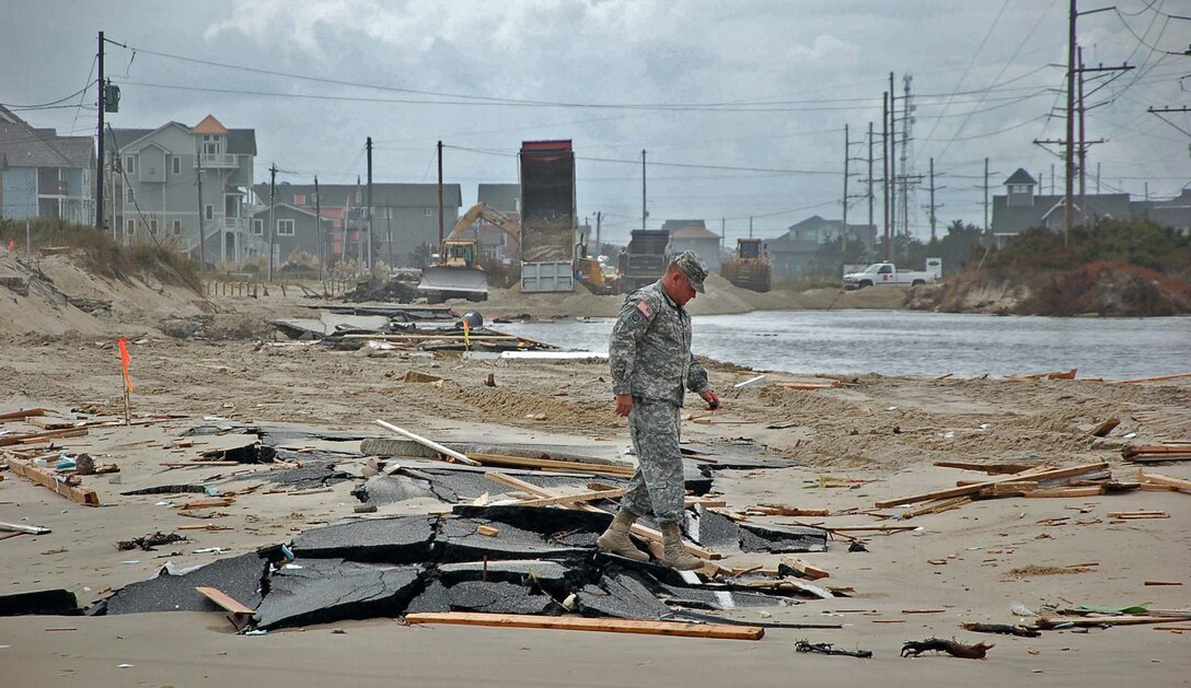 Wilmington District Commander Col. Steve Baker walks over a breached area of Highway 12 in Rodanthe after Hurricane Irene hit coastal North Carolina in late August of 2011.  When the highway breached at Rodanthe the only access to the town and other parts of the Outer Banks was by ferry.  The dredge MERRITT helped ensure that ferries could get supplies and equipment to the hard hit areas by removing shoals from the federal channel.  (USACE photo by Hank Heusinkveld)