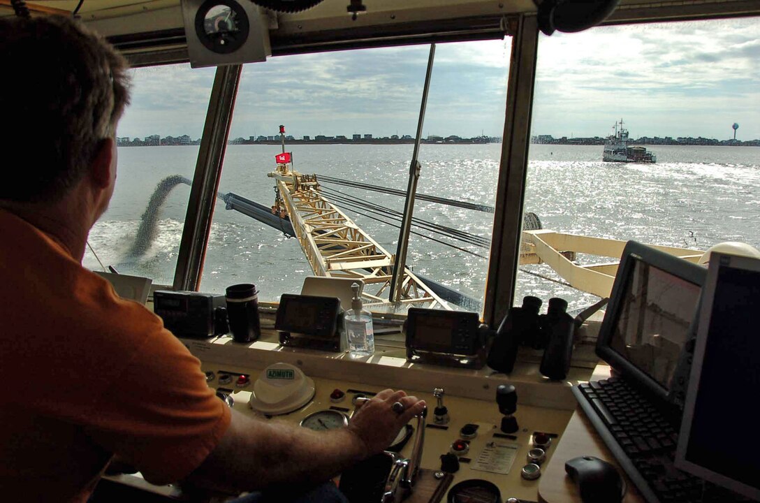 After Hurricane Irene hit coastal North Carolina in late August of 2011, Mate Barry Stull pilots the sidecast dredge MERRITT behind a ferry that was bringing equipment and supplies to Rodanthe.  The MERRITT helped clear the federal channel of shoals to help North Carolina Department of Transportation ferries continue operating.  (USACE photo by Hank Heusinkveld)  