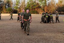 Servicemembers from Combat Logistics Regiment 27, 2nd Marine Logistics Group carry one teammate on a stretcher during a physical training session aboard Camp Lejeune, N.C., Jan. 11, 2013. This team of Marines battled against other three-man-teams to prove they were the strongest at the event and earning them a day off work.