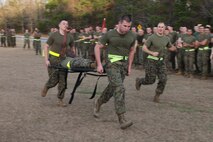 Marines from Combat Logistics Regiment 27, 2nd Marine Logistics Group carry one teammate on a stretcher during a physical training session aboard Camp Lejeune, N.C., Jan. 11, 2013. This team of Marines battled against other three-man-teams to prove they were the strongest at the event and earning them a day off work.