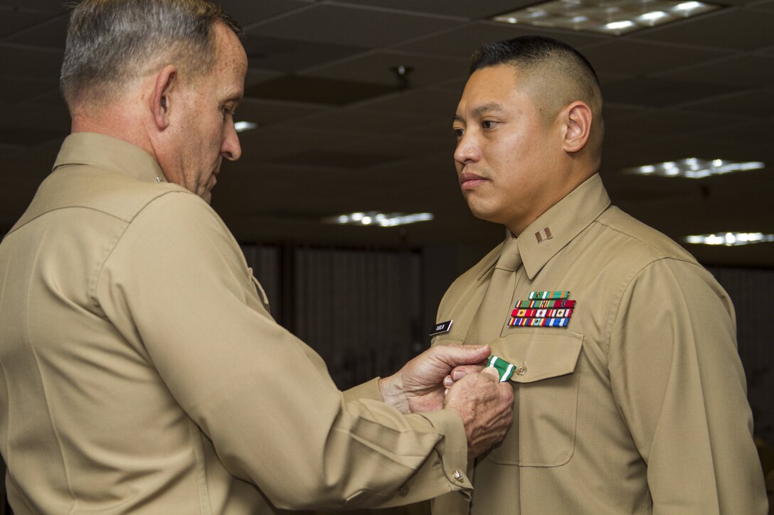 Captain Leo Tabilin, officer selection officer, Officer Selection Station San Jose, Calif., is awarded the Navy and Marine Corps Commendation Medal by Lt. Gen. Robert G. Milstead, Jr., commanding general, Marine Corps Recruiting Command, during MCRC’s 2013 National Officer Selection Officer Conference here Jan. 14. Tabilin, of Vallejo, Calif., received The Captain Robert Mullan Award for being the most successful OSO in the nation during fiscal year 2012.