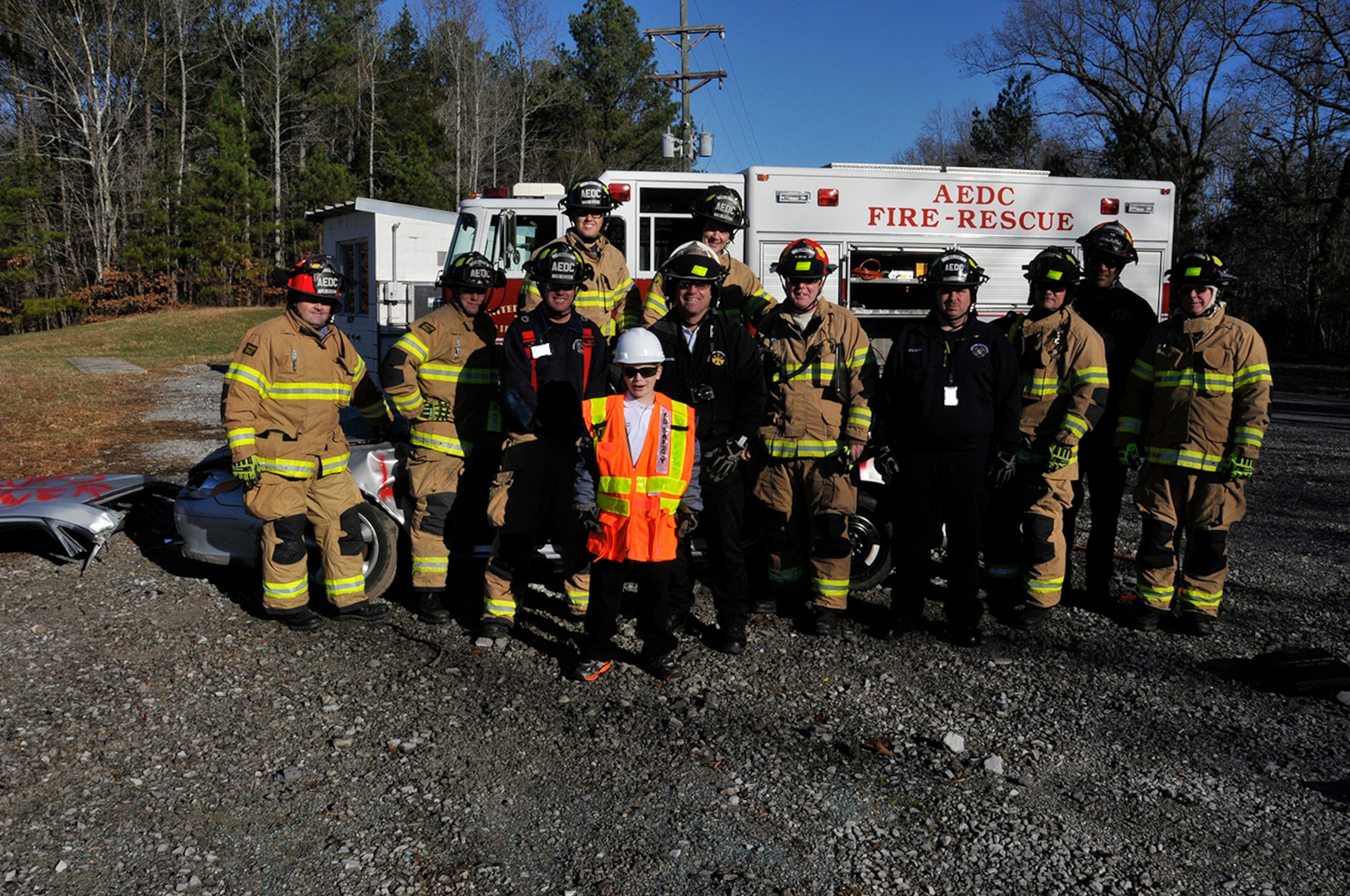 The AEDC Fire Department, represented by, from left to right, Kip Luttrell, crew chief; John Templeton, firefighter; Joey Edwards, driver operator; Sam Teat, fire fighter; Tom Lombard, assistant chief; Lonnie Brown, driver/operator; Dwane Kimmel, crew chief; Billy Miles, paramedic/firefighter; Jay Baldwin, driver/operator; Odell Crutchfield, crew chief; and Carey Powers, driver/operator, hosted Mark Kelly Olson during the young man’s recent visit to the base. Olson is a 10-year-old boy who was diagnosed with very high-risk, acute lymphocytic leukemia in May and was later adopted by the Arnold AFB Fire Department as their new deputy fire chief. While visiting AEDC, Olson got the opportunity to play the role as honorary fire chief, conducting roll call, inspecting firefighting equipment and helping to demolish a car, symbolizing the young man’s battle with cancer. Olson’s father, Mark, is an ATA operations controller at Arnold Air Force Base. (Photo by Rick Goodfriend) 