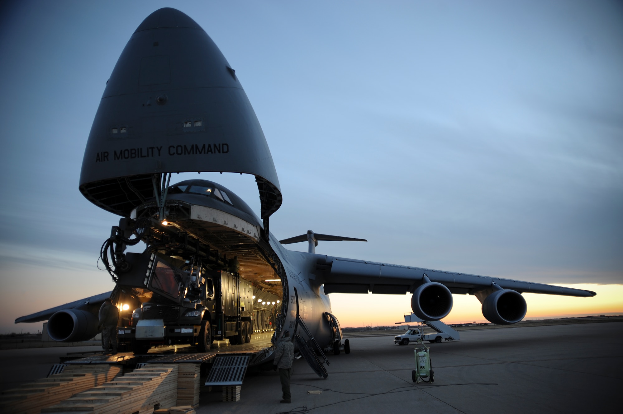 Airmen of the 22nd Logistics Readiness Squadron load two de-iceing trucks onto a C-5M Super Galaxy assigned to Dover Air Force Base, Del., Jan. 14, 2013, McConnell Air Force Base, Kan. The Super Galaxy is one of the largest cargo jets in the world and one of the few capable of transporting the trucks. (U.S. Air Force photo/Airman 1st Class Jose L. Leon)