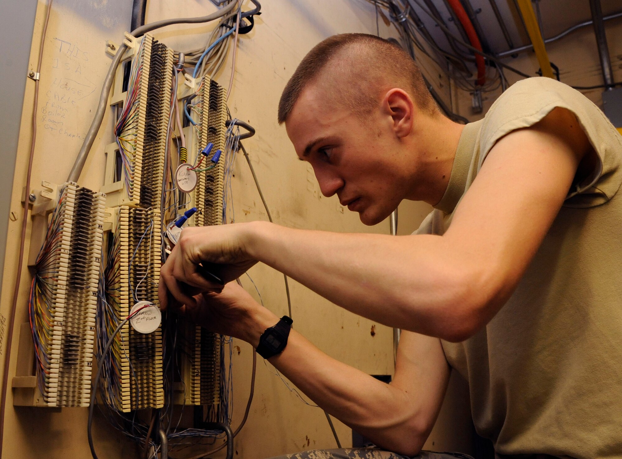 Airman 1st Class Jesse Hickman, 2nd Communications Squadron cable and antenna systems, removes old wiring from a wall on Barksdale Air Force Base, La., Jan. 16. Airmen in this section repair and replace wiring and cables across the base and maintain the base's antennas, which are vital to communication. (U.S. Air Force photo/Airman 1st Class Andrew Moua)