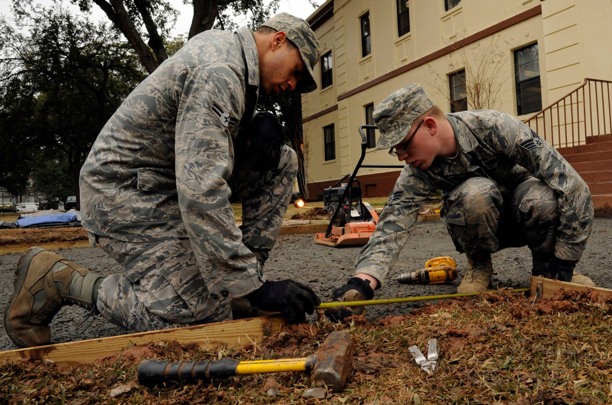 Airman 1st Class Andre Avilez and Senior Airman Kyle Farmer, 2nd Civil Engineer Squadron, take measurements to place wood frames in preparation for laying down sidewalk on Barksdale Air Force Base, La., Jan. 16. The 2 CES has the responsibility of maintaining base infrastructure and setting up construction projects. (U.S. Air Force photo/Airman 1st Class Andrew Moua)