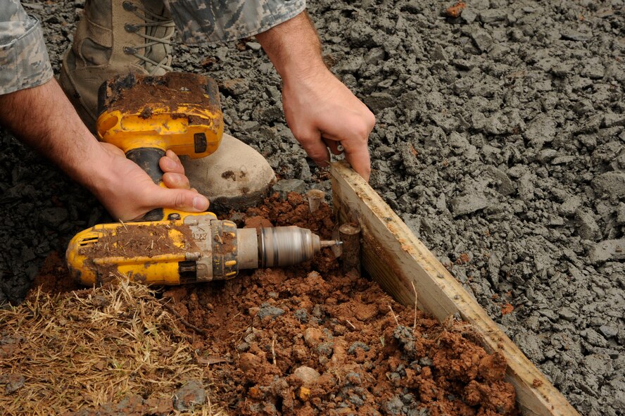 Staff Sgt. Levi Chism, 2nd Civil Engineer Squadron, drills a board in preparation of laying down sidewalk on Barksdale Air Force Base, La., Jan. 16. The board will form a frame for the sidewalk to help keep its shape. (U.S. Air Force photo/Airman 1st Class Andrew Moua)