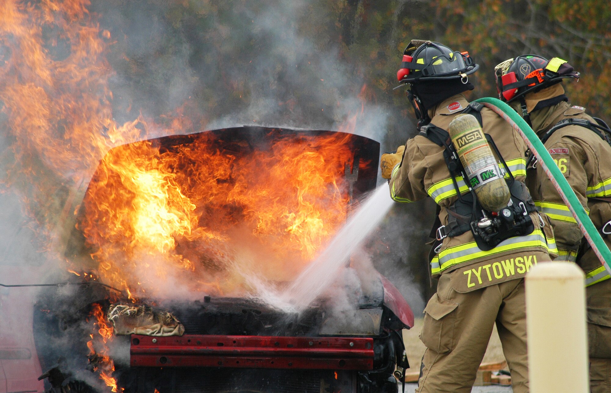 Robins firefighters Daniel Zytowski and John Whitson extinguish a car fire during a training exercise Jan. 10. The exercise scenario involved a two-car accident involving one vehicle on fire with an injured person outside of the car and two injured passengers in the second car on Beale Drive near Bldg. 10.(U. S. Air Force photo/Sue Sapp)