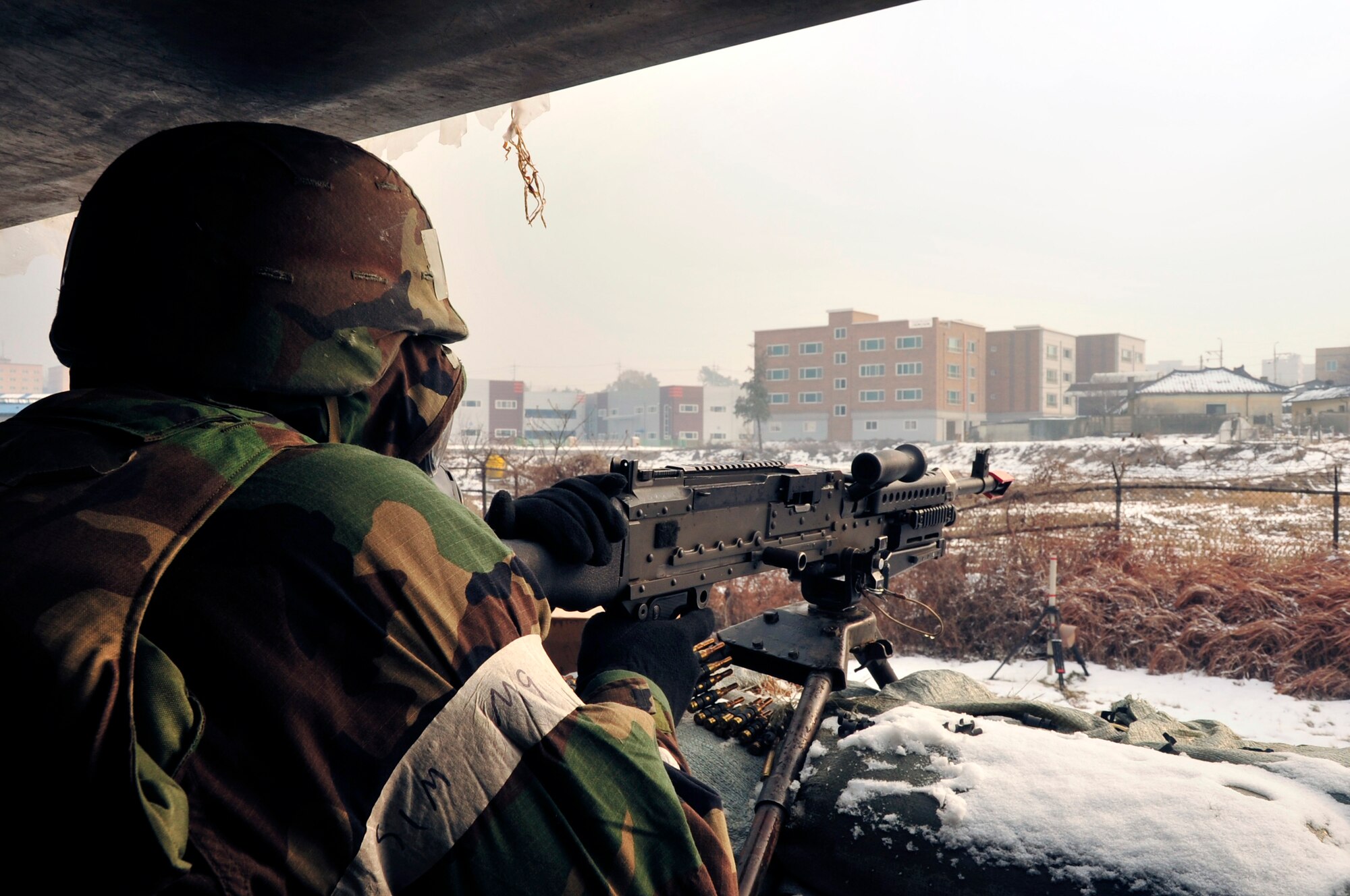 Senior Airman Christopher Parks, 51st Communications Squadron network control center operator and 51st Security Forces Squadron augmentee, scans the area for opposing forces from a Defensive Fighting Position during exercise Beverly Midnight 13-01 at Osan Air Base, Republic of Korea, Jan. 16, 2012. During OREs, Airmen highlight their ability to position, employ, and sustain forces and showcase operational readiness. BM 13-01 is the first ORE of the 2013. (U.S. Air Force photo/Airman 1st Class Alexis Siekert)