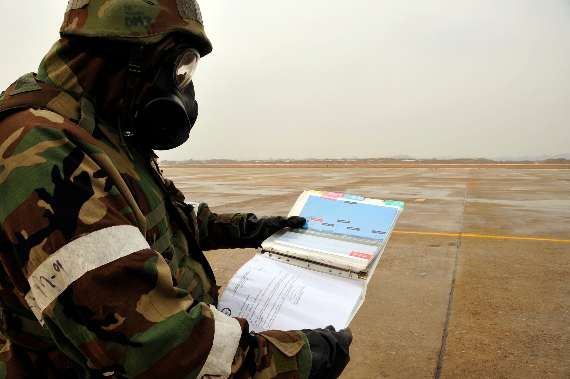 Master Sgt. Brian Nuss, 51st Operational Support Squadron Weather Flight craftsman, checks flight light visibility while in Mission Oriented Protective Posture 4 gear as part of operational readiness exercise Beverly Midnight 13-01 at Osan Air Base, Republic of Korea, Jan. 16, 2012. MOPP 4 is worn post-attack, and when contamination is present or suspected or the highest level of protection is required. (U.S. Air Force photo/Airman 1st Class Alexis Siekert)