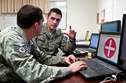 Senior Airman Daniel Burkhardt (facing) and Staff Sgt. Christopher Bevins, both Air Force broadcast journalists currently supporting Joint Task Force, National Capital Region, a task force of Department of Defense military and civilian personnel stood up in support of the 57th Presidential Inauguration, put the finishing touches on a cellphone application, Jan. 14, that they designed from the ground up to provide real time information on the historic event. Burkhardt and Bevins have come from 11th Wing Public Affairs at Joint Base Andrews, Md. Their app, called "Inauguration," was released by Apple Inc., Jan. 14 and is currently available through the corporation's App Store. (U.S. Army photo by Sgt. Christopher M. Gaylord, 5th Mobile Public Affairs Detachment)
