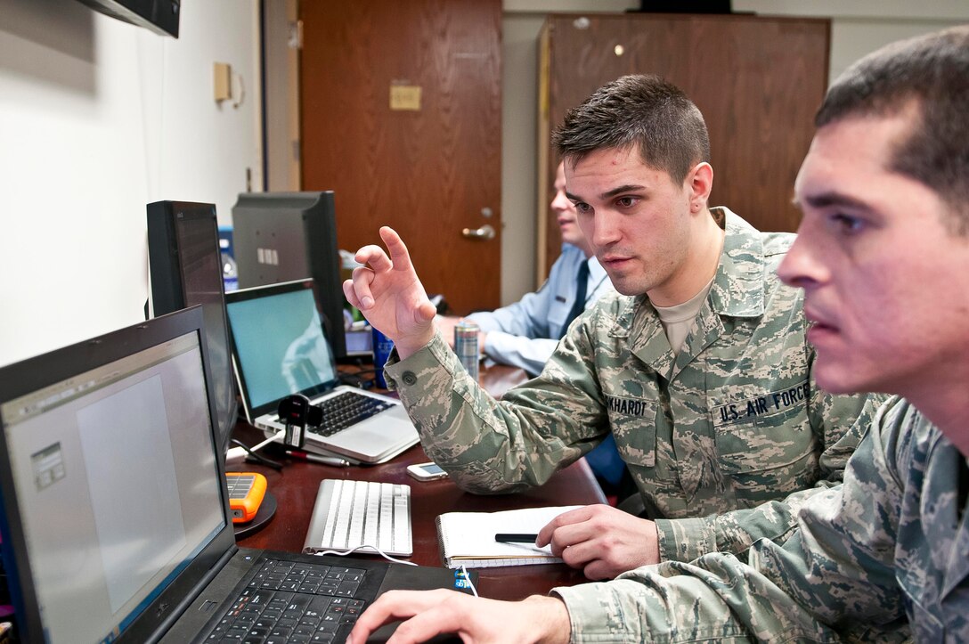Senior Airman Daniel Burkhardt (left) and Staff Sgt. Christopher Bevins, both Air Force broadcast journalists currently supporting Joint Task Force, National Capital Region, a task force of Department of Defense military and civilian personnel stood up in support of the 57th Presidential Inauguration, put the finishing touches on a cellphone application, Jan. 14, that they designed from the ground up to provide real time information on the historic event. Burkhardt and Bevins have come from 11th Wing Public Affairs at Joint Base Andrews, Md. Their app, called "Inauguration," was released by Apple Inc. Jan. 14 and is currently available through the corporation's App Store. (U.S. Army photo by Sgt. Christopher M. Gaylord, 5th Mobile Public Affairs Detachment)