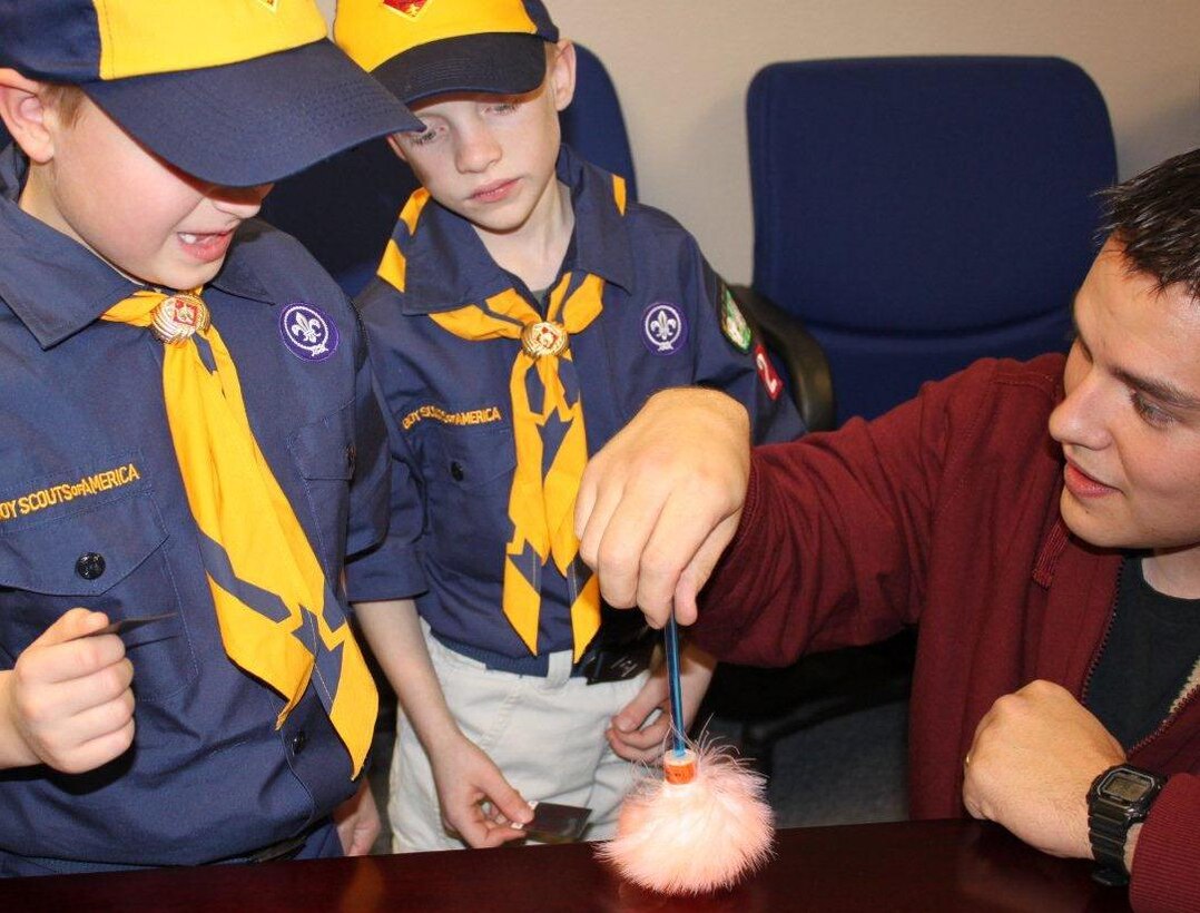 Special Agent Benjamin Tallman, OSI Detachment 226, Ellsworth Air Force Base, S.D., shows two cub scouts from a local cub scout den how to brush for fingerprints. The scouts were invited to the detachment to fulfill a requirement toward getting their "wolf badge." (U.S. Air Force Photo/OSI Det. 226)