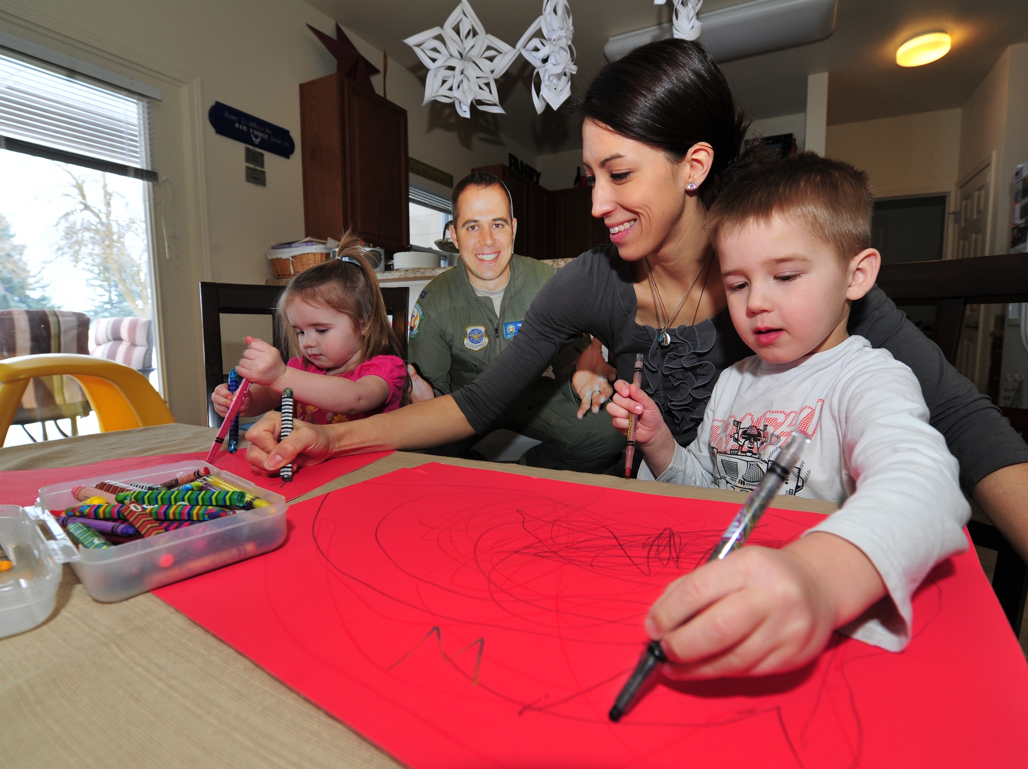 Megan Capelle and her children Gabriel, 4, and Abigail, 2, make “welcome home” signs Jan. 15, 2013 for Capt. Michael Capelle, who returns from a deployment Monday. Capelle is due with her third child in August. Her husband is a KC-135R Stratotanker pilot with the 93rd Air Refueling Squadron. (U.S. Air Force photo by Senior Airman Taylor Curry)