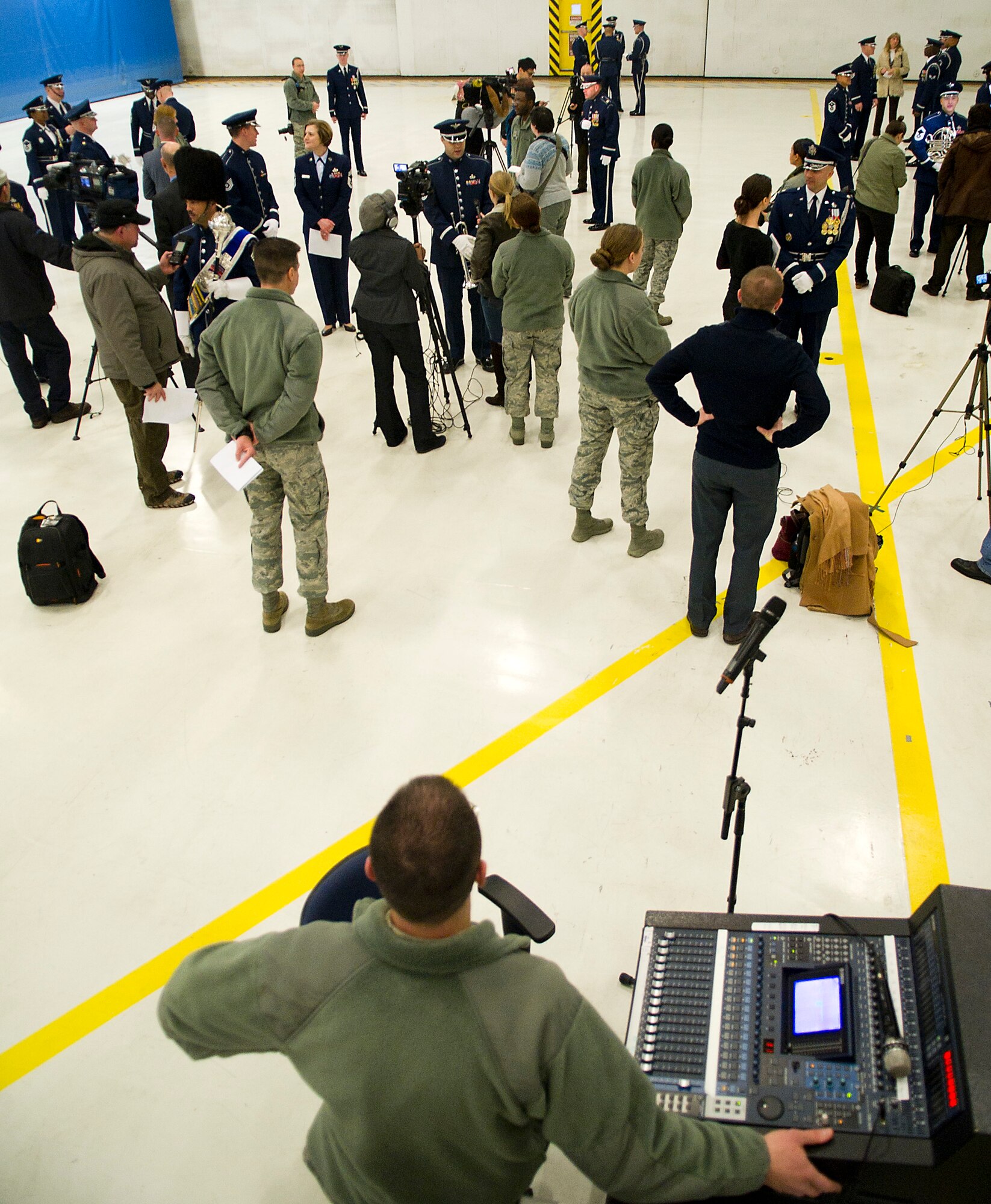 Master Sgt. Adam Dempsey, U.S. Air Force Band audio engineer, looks on as more than 20 media outlets interview various Airmen from the USAF Band and Honor Guard following the Air Force rehearsal Jan. 11, 2013 at Joint Base Andrews, Md. Dempsey, a native of Dexter, Mich., has been with the band for eight years and the 2013 Inauguration will be the second one he has supported. (U.S. Air Force photo by 1st Lt. Ashleigh Peck)