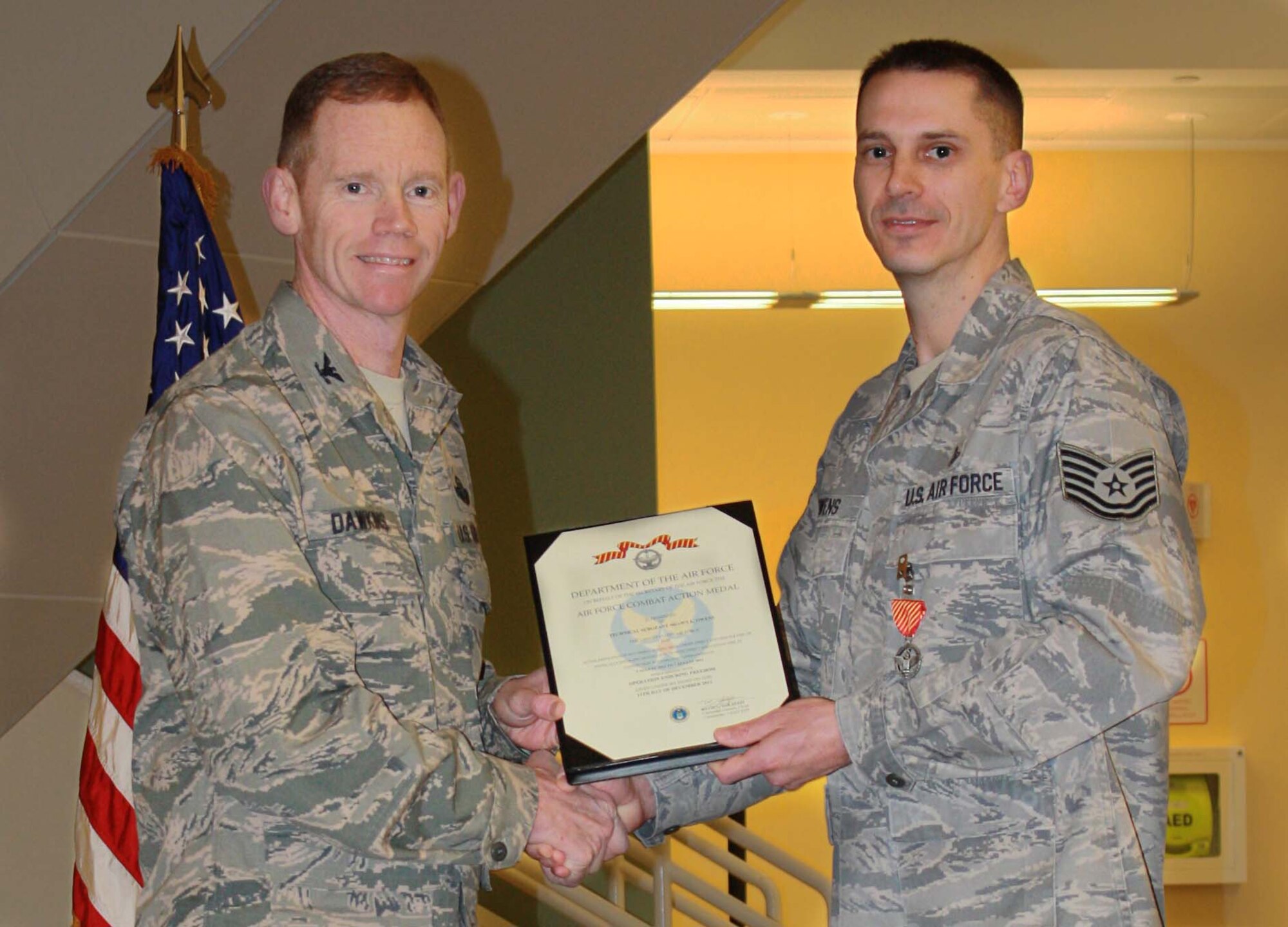MINOT AIR FORCE BASE, N.D. -- Tech. Sgt. Shawn Owens, 5th Medical Operations Squadron operational medicine flight chief, recently earned distinguished military decorations for going above the call of duty during multiple deployments. Col. James Dawkins Jr., the recently departed 5th Bomb Wing commander, presented Owens the Air Force Combat Action Medal and the Purple Heart here, Jan. 10. (U.S. Air Force Photo/Kiley Swopes) 
