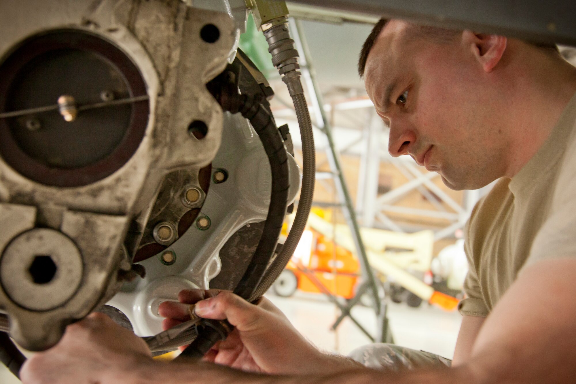 Staff Sgt. David Desormey, 934th Maintenance Squadron, replaces the clamp on the hydraulic hoses as part of the landing gear assembly on a C-130 at the Minneapolis-St. Paul Air Reserve Station, Minn. (U.S. Air Force Photo/Shannon McKay)
