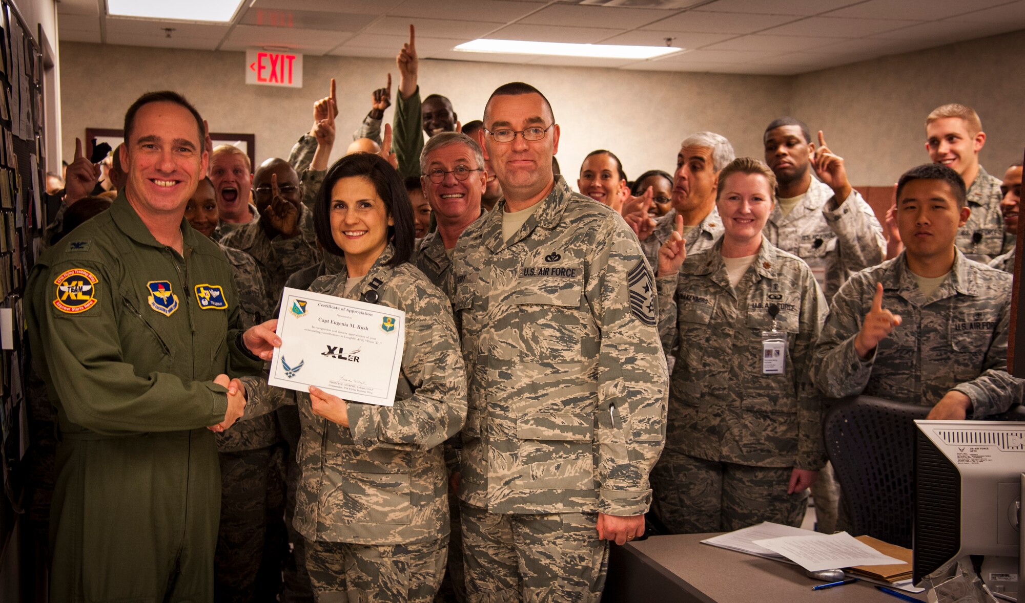 Capt. Eugenia Rush, 47th Medical Group disease manager, infection prevention and credentialing manager, poses with Col. Tom Murphy, 47th Flying Training Wing commander, and Chief Master Sgt. Garry Berry, 47th FTW command chief, after being presented the XLer of the week award at Laughlin Air Force Base, Texas, Jan. 9, 2013. The XLer is a weekly award chosen by wing leadership and given to those who consistently make outstanding contributions to Laughlin and their unit. (U.S. Air Force photo/Senior Airman Nathan Maysonet)