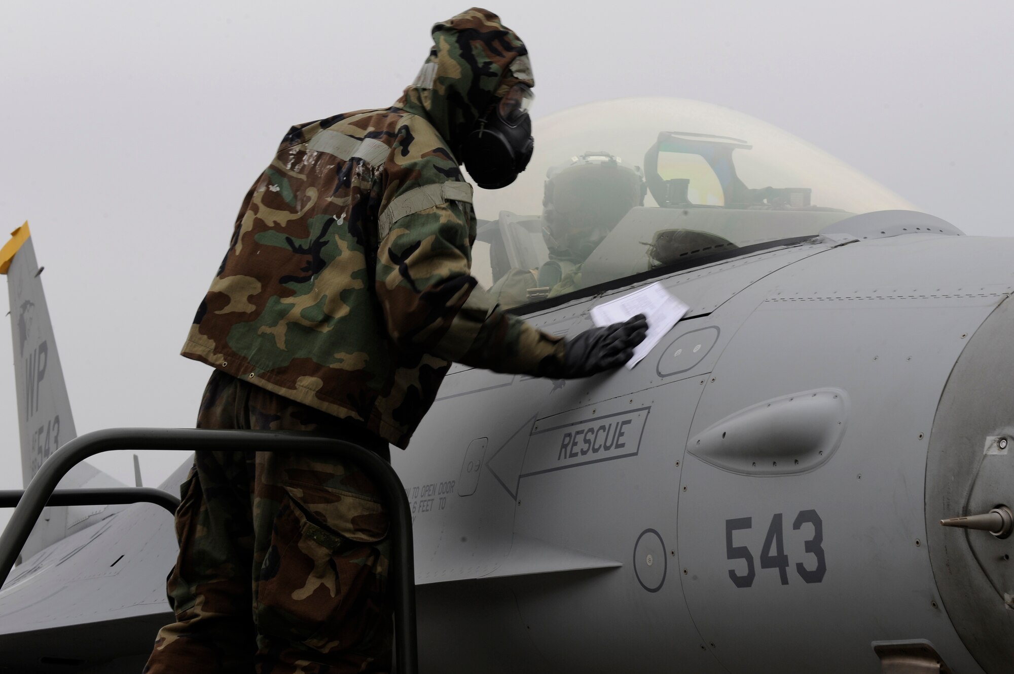 Senior Airman Clinton Caruolo, 8th Aircraft Maintenance Squadron, decontaminates an F-16 Fighting Falcon during Exercise Beverly Midnight 13-1 at Kunsan Air Base, Republic of Korea, Jan. 16, 2013. The aircraft had to be free of chemical hazards around the hatch before allowing the pilot to exit the cockpit. (U.S. Air Force photo by Senior Airman Marcus Morris/Released)