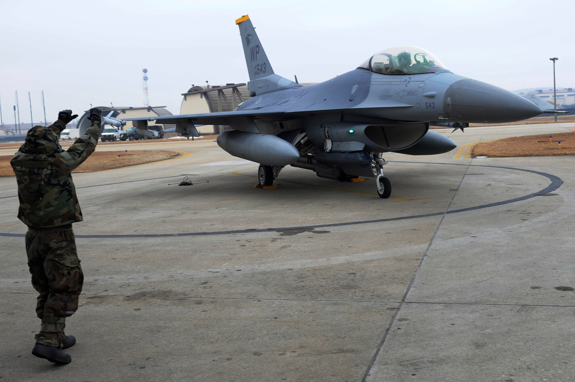 Senior Airman Clinton Caruolo, 8th Aircraft Maintenance Squadron, marshalls in an F-16 Fighting Falcon during exercise Beverly Midnight 13-1 at Kunsan Air Base, Republic of Korea, Jan. 16, 2013. Caruolo quickly grounded the aircraft and prepared it for the pilot to exit. (U.S. Air Force photo by Senior Airman Marcus Morris/Released)