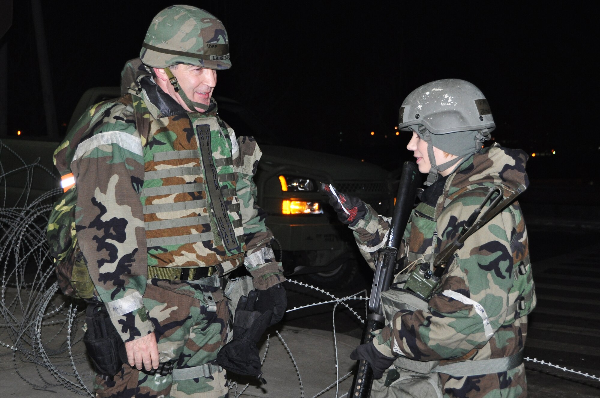 Airman 1st Class Brandi Bratz, 51st Security Forces member, checks for proper identification of Col. Christopher Lauritzen, 51st Dental Squadron commander, before allowing him access through an entry control point during exercise Beverly Midnight 13-01 Jan. 15, 2013. These exercises tests Osan Airmen’s abilities during a heightened state of readiness while providing combat ready forces for close air support, air strike control, counter air, interdiction, theater airlift, and communications in the defense of the Republic of Korea. (U.S. Air Force photo/Senior Airman Kristina Overton)