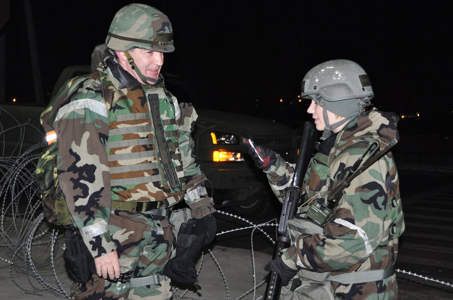 Airman 1st Class Brandi Bratz, 51st Security Forces member, checks for proper identification of Col. Christopher Lauritzen, 51st Dental Squadron commander, before allowing him access through an entry control point during exercise Beverly Midnight 13-01 Jan. 15, 2013. These exercises tests Osan Airmen’s abilities during a heightened state of readiness while providing combat ready forces for close air support, air strike control, counter air, interdiction, theater airlift, and communications in the defense of the Republic of Korea. (U.S. Air Force photo/Senior Airman Kristina Overton)
