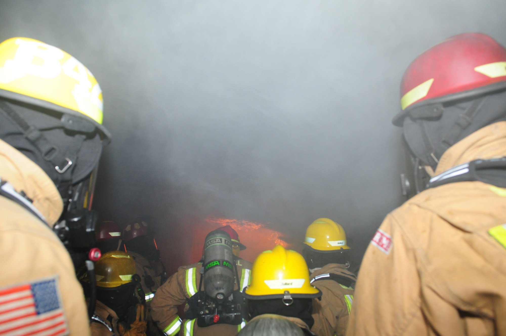 Thick smoke starts to descend in a thermal layer as firefighters watch a fire develop in a compartment fire behavior trainer Jan. 10, 2013, at RAF Mildenhall, England. The trainer, which cost approximately $27,000, is a converted shipping container and a vital training aid to the 100th Civil Engineer Squadron Fire Department. (U.S. Air Force photo by Karen Abeyasekere/Released)