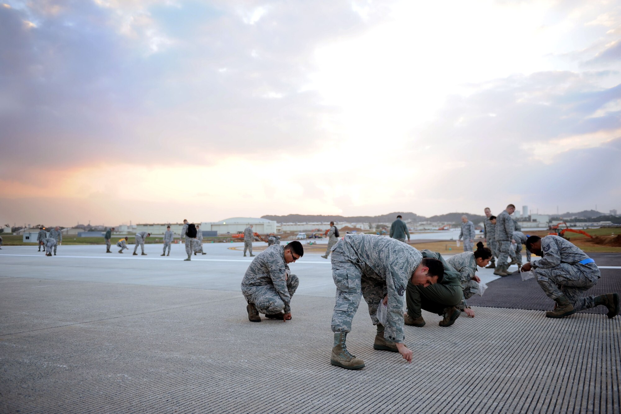 U.S. Air Force Airmen from Kadena Air Base pick up rocks from a runway on Kadena Air Base, Japan, Jan. 14, 2013. The Airmen were participating in a Foreign Objects and Debris walk in order to ensure safety for not only aircraft but Airmen’s lives. (U.S. Air Force photo by Airman 1st Class Brooke P. Doyle)