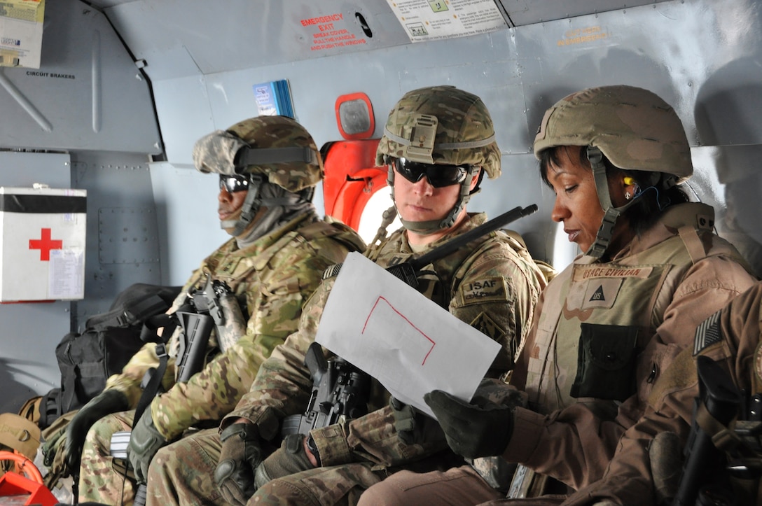 Lori Gardner (right), the Afghanistan Engineer District-South Tarin Kowt Resident Office Engineer, and Capt. Daniel Sunden, the resident office officer in charge, review site plans on a helicopter ride to a U.S. Army Corps of Engineers project site in Uruzgan province, Afghanistan.