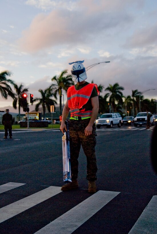 MARINE CORPS BASE HAWAII - "A storm trooper" from 2nd Battalion, 3rd Marine Regiment, waits for his fellow Marines to cross the intersection during a special unit toy run, Dec. 21, 2012. The unit went on a three-mile morning run, with many of the service members carrying toys and wearing festive decor. The unit collected more than 700 toys for the program. "We know a lot of families (and military families) benefit from (Toys for Tots)," said Maj. Brian Harvey, operations officer, Headquarters and Service Company, 2nd Bn., 3rd Marines. "This is our way of giving back." After the run, the "Island Warriors" loaded the toys into a truck and enjoyed some breakfast and social time. This is the unit's second year giving to Toys for Tots. Last year, they went on a hike, carrying gear and toys. "It's a fun way to start the holiday season and give back to the local community," said Lt. Col. Justin S. Dunne, 2nd Bn., 3rd Marines commanding officer. (Official U.S. Marine Corps photo by Kristen Wong) 