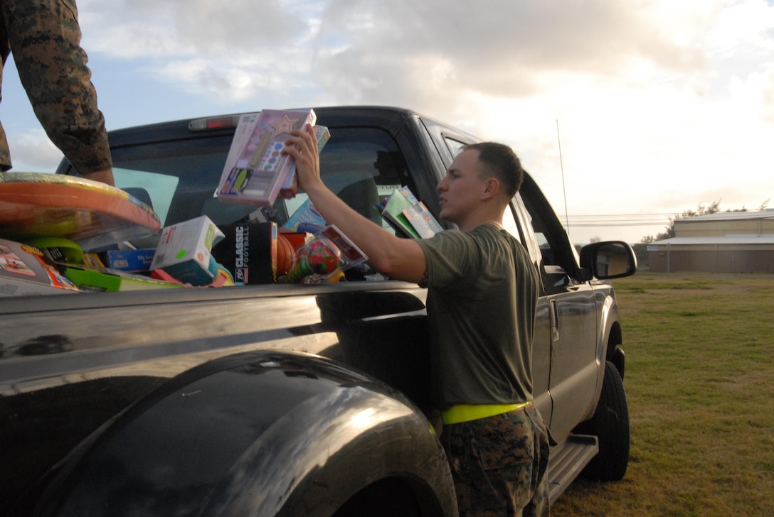 MARINE CORPS BASE HAWAII - Cpl. Ricardo Hernandez Gomez, a Marine with Echo Company, 2nd Battalion, 3rd Marine Regiment, helps load toys into a truck, Dec. 21, 2012. The unit went on a three-mile morning run, with many of the service members carrying toys and wearing festive decor. The unit collected more than 700 toys for the program. "We know a lot of families (and military families) benefit from (Toys for Tots)," said Maj. Brian Harvey, operations officer, Headquarters and Service Company, 2nd Bn., 3rd Marines. "This is our way of giving back." After the run, the "Island Warriors" loaded the toys into a truck and enjoyed some breakfast and social time. This is the unit's second year giving to Toys for Tots. Last year, they went on a hike, carrying gear and toys. "It's a fun way to start the holiday season and give back to the local community," said Lt. Col. Justin S. Dunne, 2nd Bn., 3rd Marines commanding officer. (Official U.S. Marine Corps photo by Kristen Wong) 