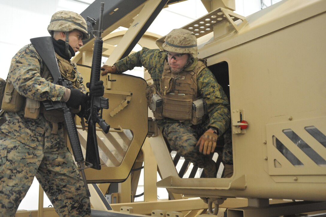 2nd Lt. Eduardo Cascante, student, Fox Co., The Basic School, helps one of his fellow Marines, 2nd Lt. Gabriel Caban, out of a Mine Resistant Ambush Protected Egress Trainer during an simulation at Camp Upshur on Jan. 16. They must keep self-control and overcome the natural fear and panic as they participate in the simulation. 