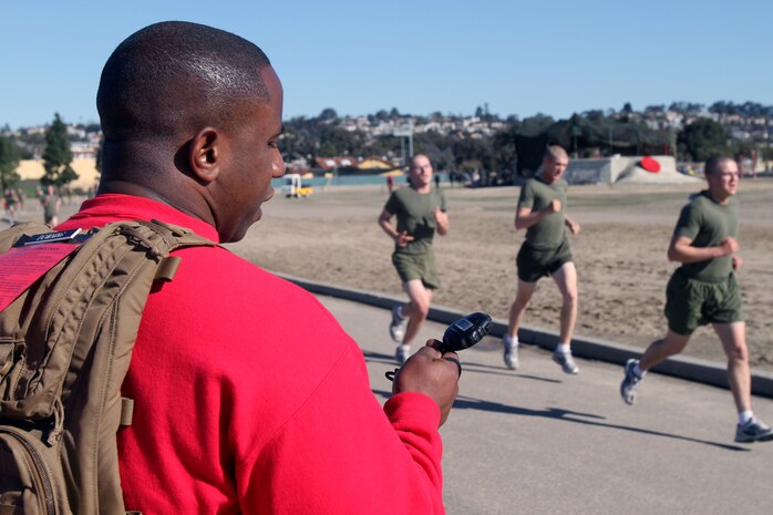 SSgt. James Downing, drill instructor, Company A, 1st Recruit Training Battalion, yells out the time as recruits cross the finish like during the inventory PFT aboard Marine Corps Recruit Depot San Diego Jan 7.  In order to achieve a perfect score, recruits must complete 20 pull-ups, 100 crunches and run three miles in 18 minutes.