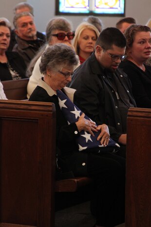 Norma Westmoreland hugs an American Flag presented to her in honor of her husband, retired 1st Sgt. William "Billy" F. Westmoreland, during his memorial service at the Marine Corps Recruit Depot San Diego Chapel Jan. 11. Westmoreland served 20 years in the Marine Corps and spent the last 14 years of his life as a volunteer docent at the Commanad Museum.  