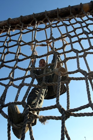A recruit of Company C, 1st Recruit Training Battalion, climbs over a cargo net wall during the Comabt Conditioning Exercise Jan. 9. 
