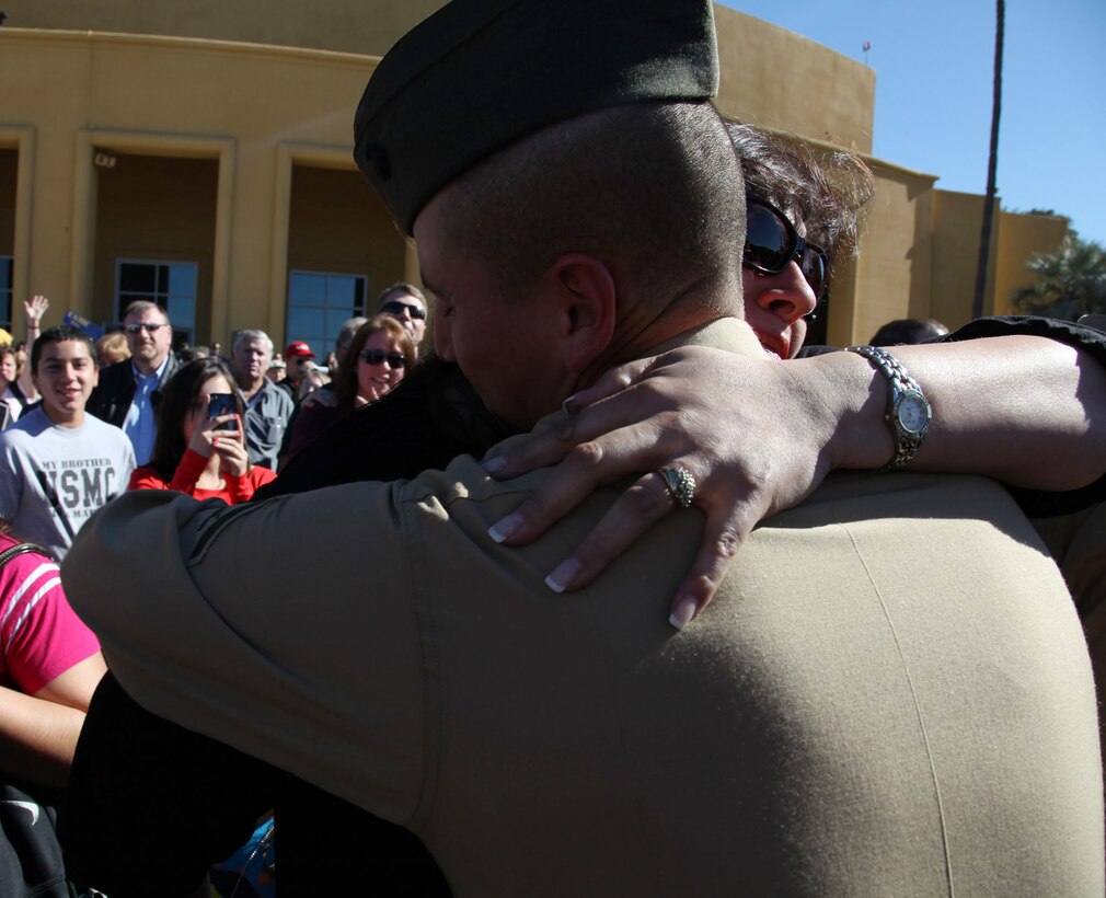 Lance Cpl. Adam Cardenas, company honorman, Mike Company, hugs his mother Viviana Cardenas, for the first time in three months while his family looks on and takes pictures of the reunion at Marine Corps Recruit Depot San Diego Jan. 17. LCpl Cardenas' family spoke highly of their him, stating that he was an excellent child growing up, stayed out of trouble and made excellent grades throughout school. 