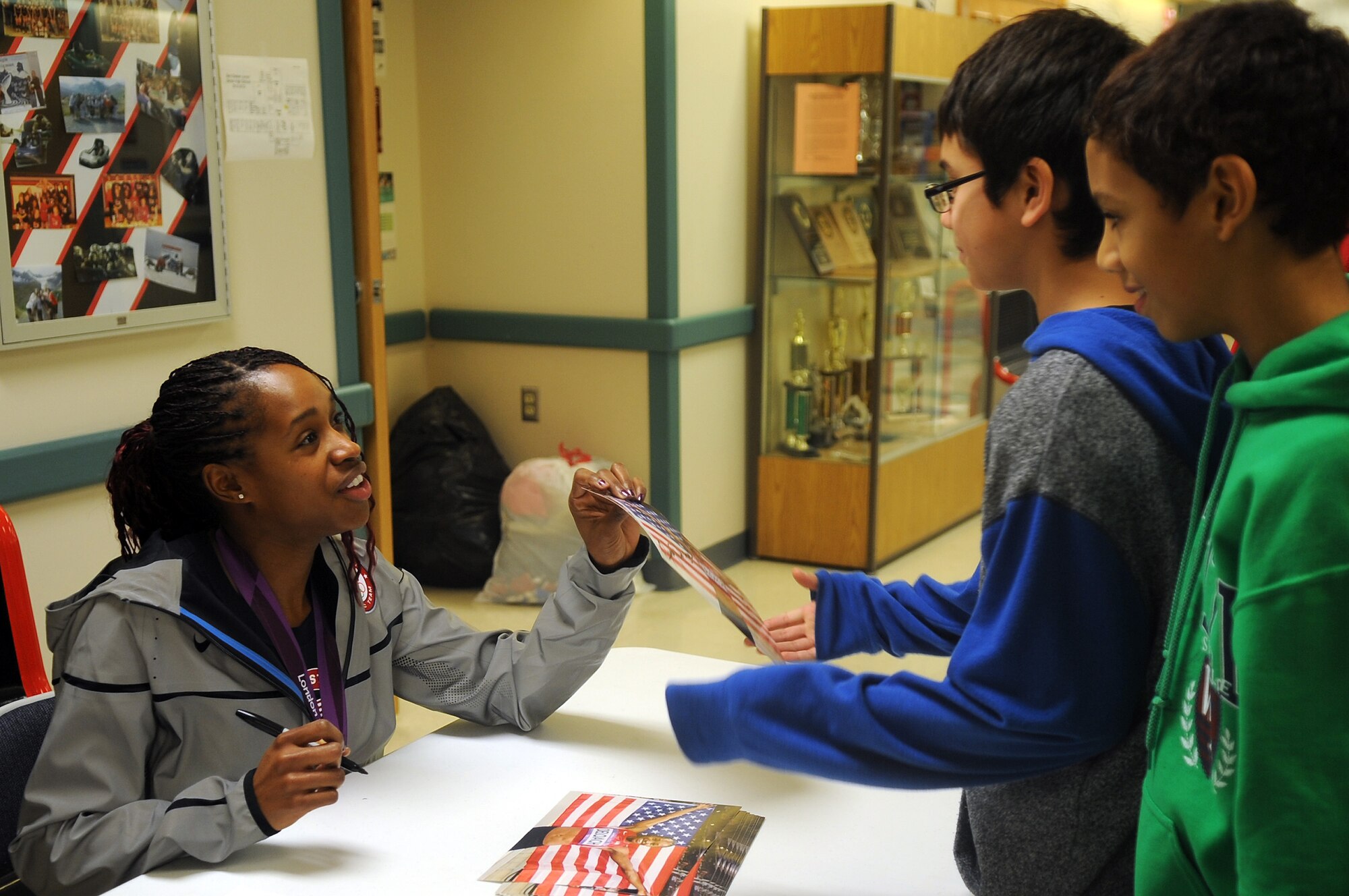 Janay DeLoach, Team USA member and Olympic long jump bronze medalist, signs autographs for students at Ben Eielson Junior-Senior High School Jan. 14, 2013, Eielson Air Force Base, Alaska. DeLoach, 28, graduated from Ben Eielson in 2003 and recently returned to share her journey from high school athlete to Olympic competitor. (U.S. Air Force photo/Airman 1st Class Zachary Perras)