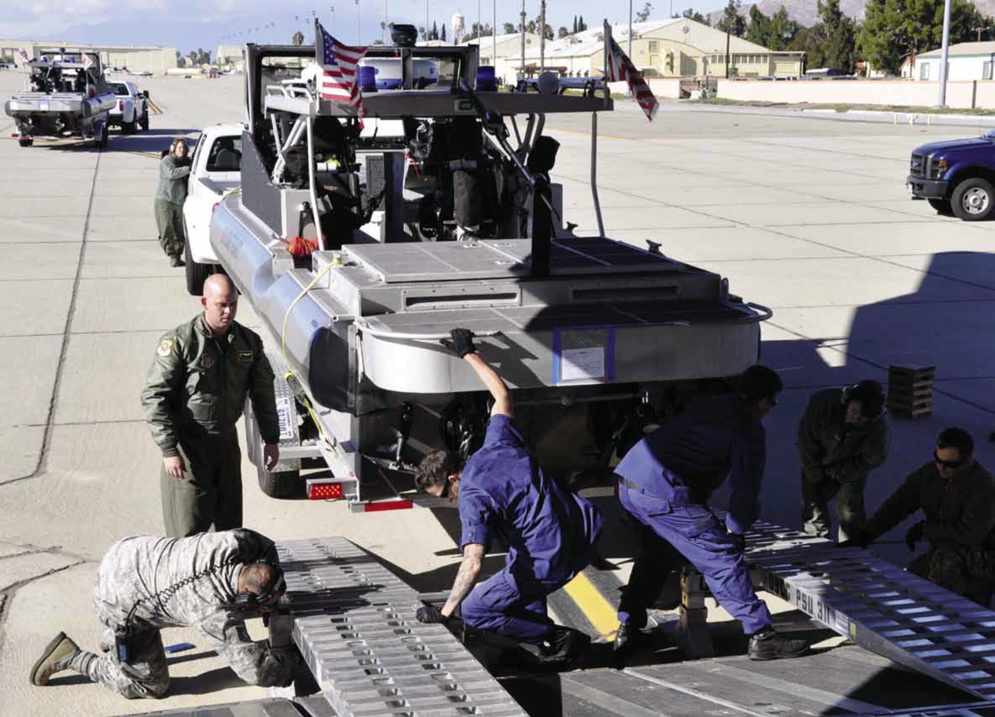 March Air Reserve Base Air Terminal Operations Center personnel and Reserve loadmasters from Dover Air Force Base, Del., assist U.S. Coast Guard members from Port Security Unit 311, based in Long Beach, Calif., with the upload of two Generation IV Transportable Port Security Boats, onto a C-17 Globemaster III, Jan. 11. It is the first-ever operational deployment for the newest generation of port security boats. They are being deployed to Guantanamo Bay, Cuba, to provide security for the waters surrounding the base. They will be replacing Generation III boats that have been in operation for 20 years. (U.S. Air Force photo by Megan Crusher)