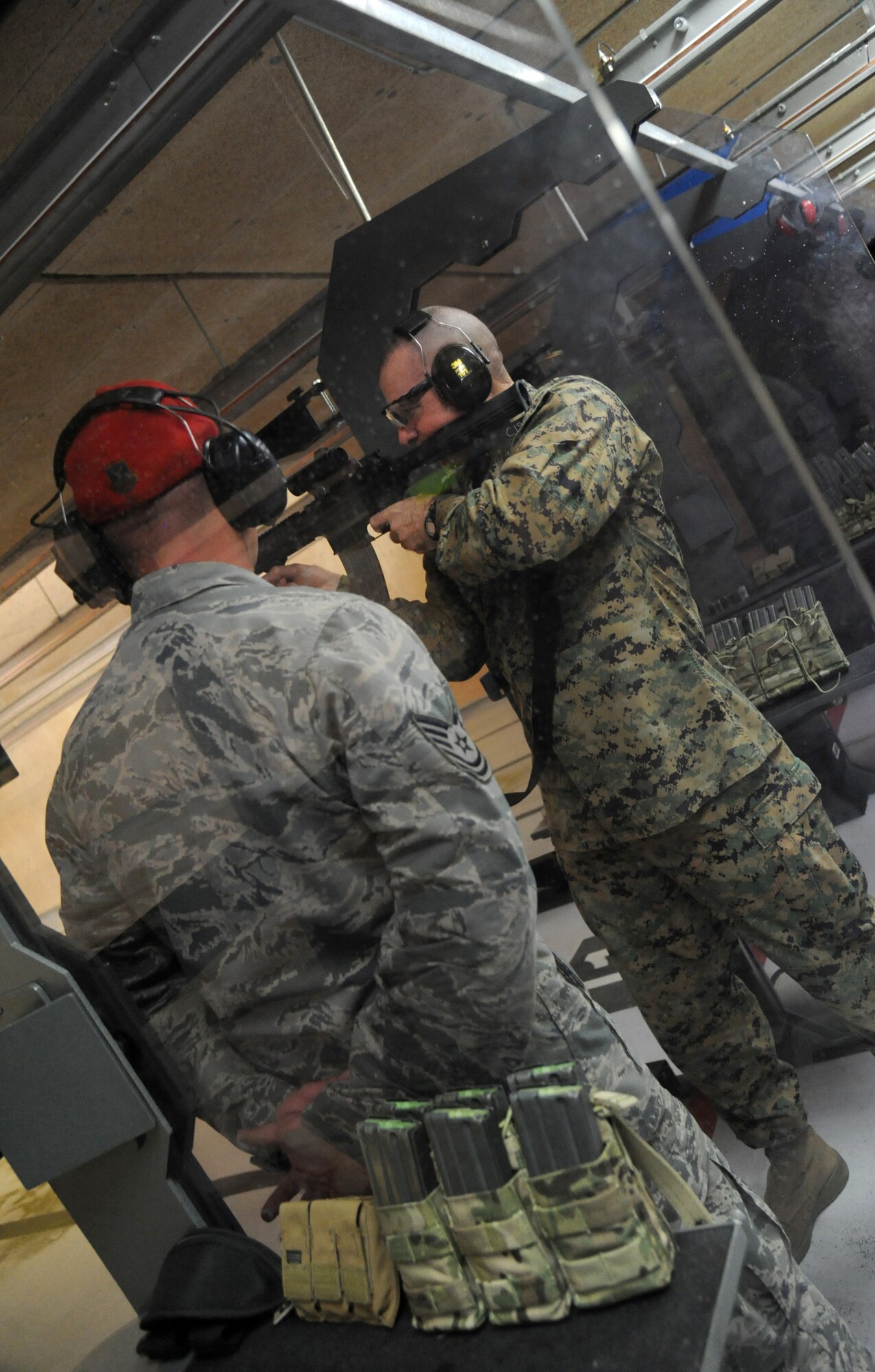 Tech. Sgt. Jonathan Johnson, 81st Security Forces combat arms, stands by for assistance as Marine Sgt. Maj. Bryan Battaglia, Senior Enlisted Advisor to the Chairman of the Joint Chiefs of Staff, fires an M4 assault rifle weapon at the indoor firing range Jan. 16, 2013, at Keesler Air Force Base, Miss.  Battaglia’s one-day visit allowed him the opportunity to acquaint himself with Keesler’s people, mission and contribution to the bigger military picture.  He also talked to enlisted Keesler members about the CJCS’ four priorities, his own key themes and his thoughts on bridging the basics and total force fitness.  (U.S. Air Force photo by Kemberly Groue)